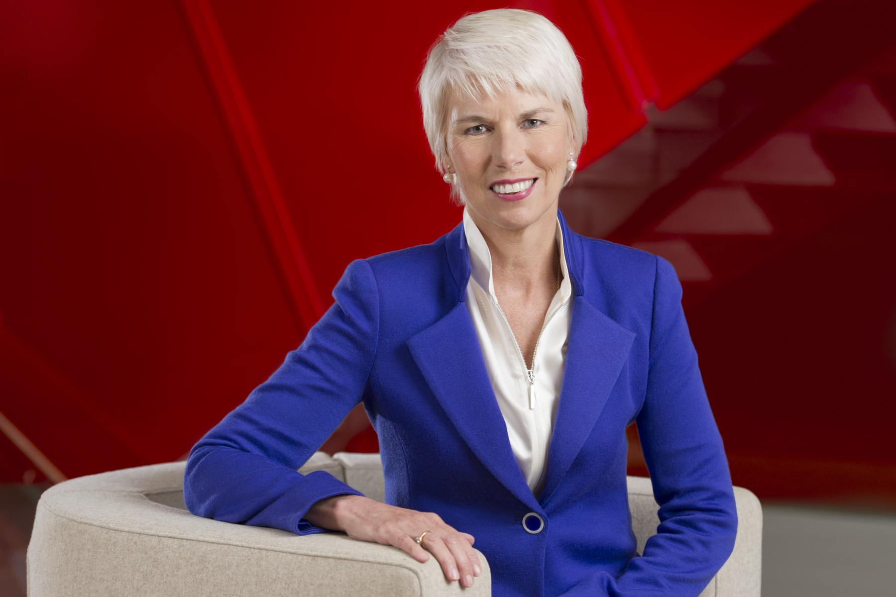 A professional corporate portrait of Gail Kelly, former CEO of Westpac A professional corporate portrait of Gail Kelly, former CEO of Westpac, seated in a modern setting with a striking red background, taken for the Westpac Annual Report. Corporate photography by Sydney photographer Gavin Jowitt.