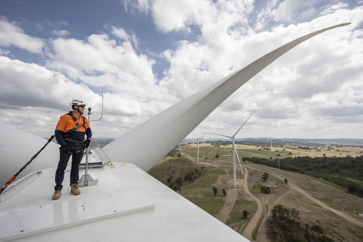 Industrial Photography of engineer on top of wind turbine